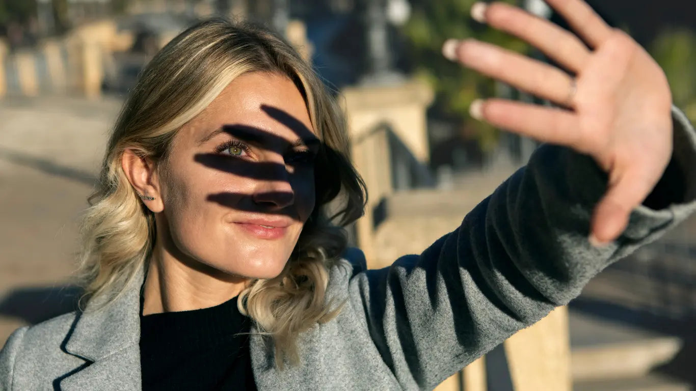 woman shielding her face from the sun